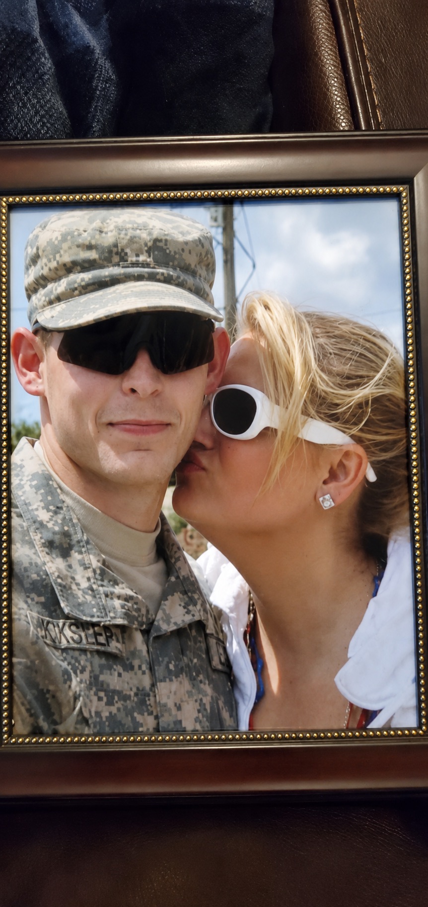 Tracy kissing her son Adam on the cheek while he is in his Army uniform, in a cherished framed family photograph